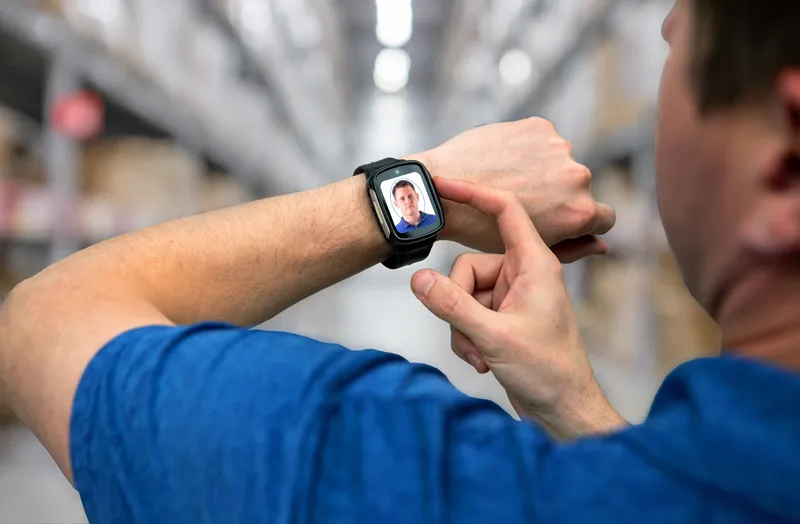 Individual captures a biometric check-in photo of himself, displaying on the BI VeriWatch on his wrist.
